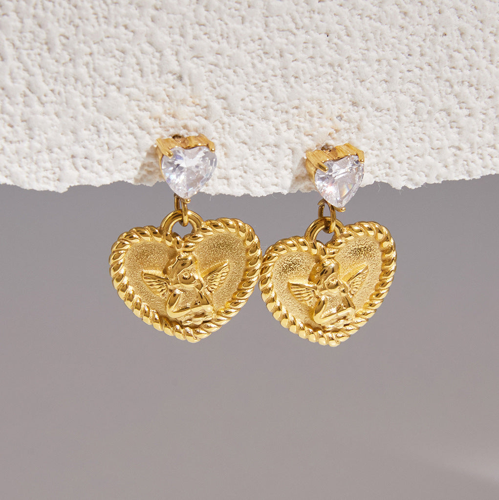 Angel heart medallion earrings hanging below clear heart studs