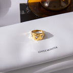 Three white accents across a gold plated ring on a book