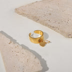 Stainless steel heart charm ring photographed between pale stone props