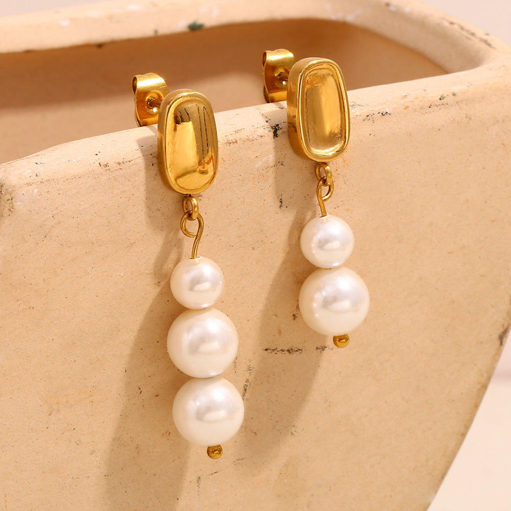 white pearl cascades below rounded gold plated studs