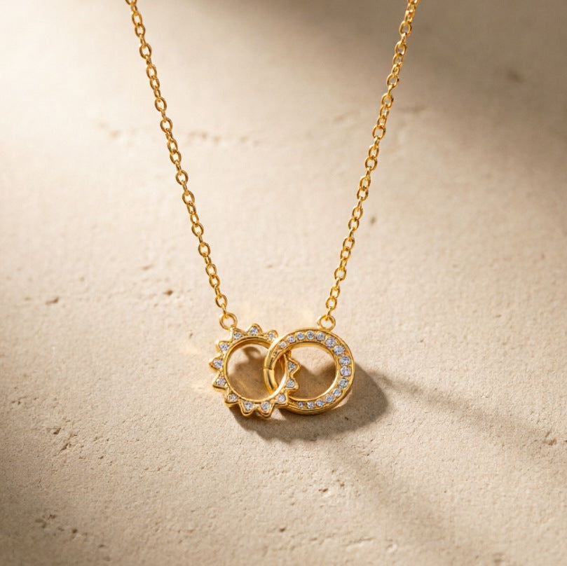 Interlocking sunburst and clear stone circle pendant on a fine chain