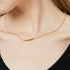 minimalist polished bar necklace worn at the collarbone