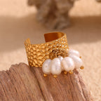 front view of the wide hammered ring and dangling white pearls