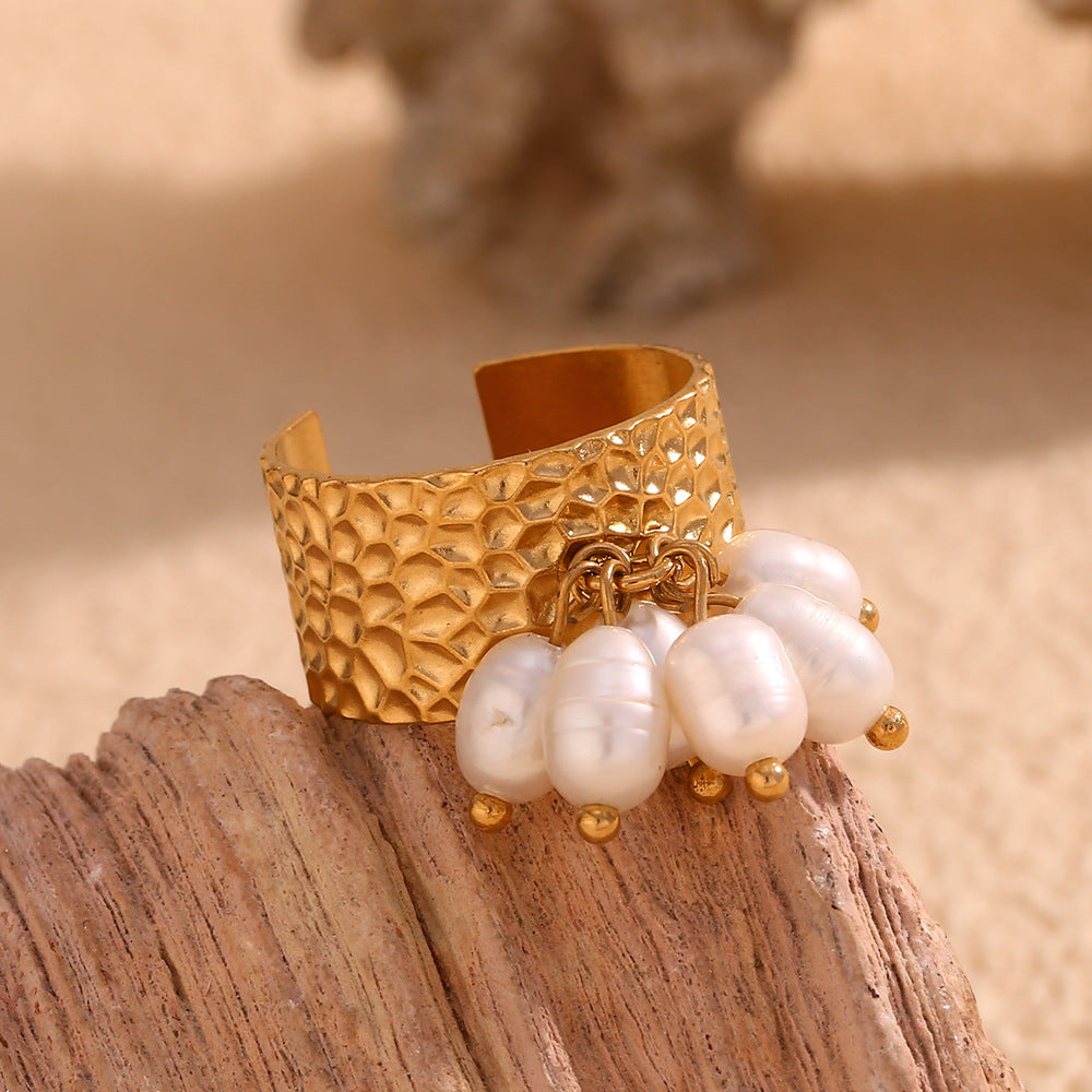 front view of the wide hammered ring and dangling white pearls
