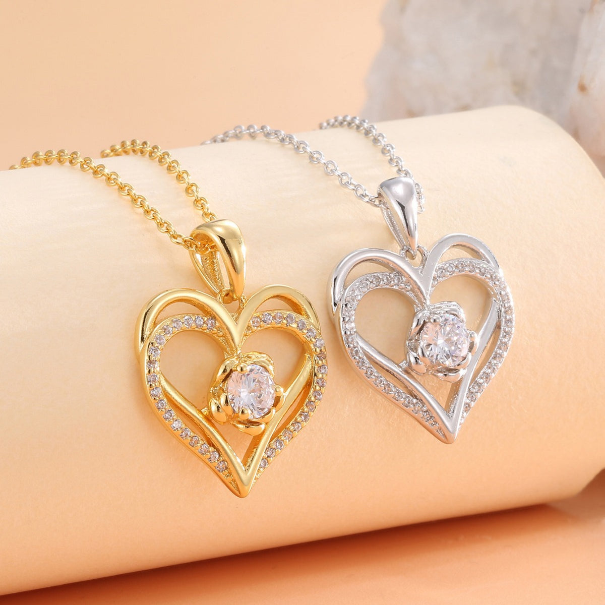 gold and silver double heart pendant necklaces displayed side by side