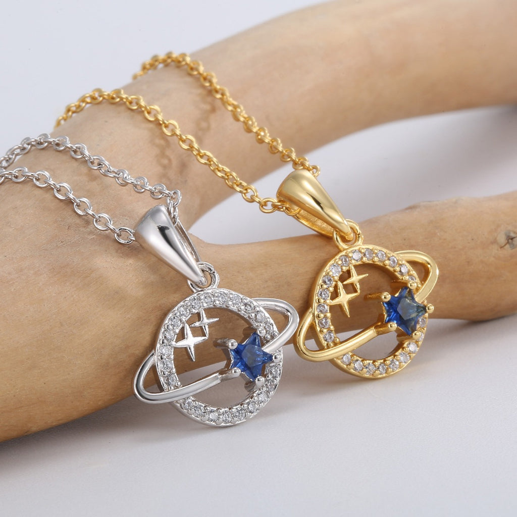 close view of ringed planet pendants with blue and clear faceted stones