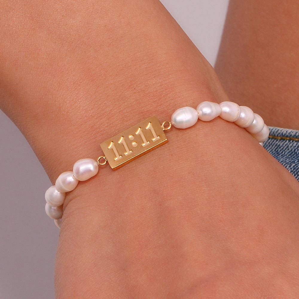 Freshwater pearl and 11:11 bracelet worn on a wrist
