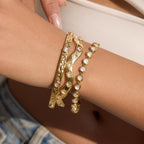 Gold plated stone bracelets and bangles stacked on a wrist