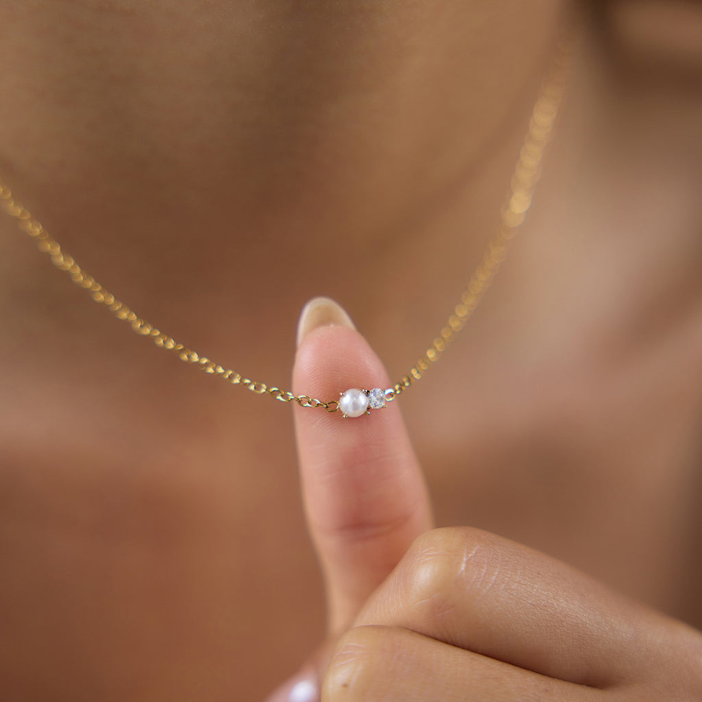Small clear solitaire necklace shown close-up on model