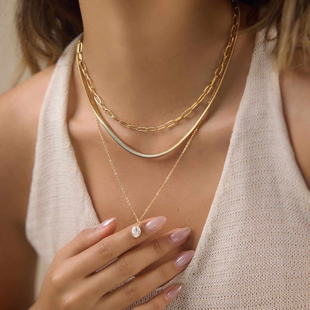 Triple layer necklace with oval pendant worn by model