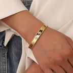 model wearing a gold plated four-leaf clover open bangle