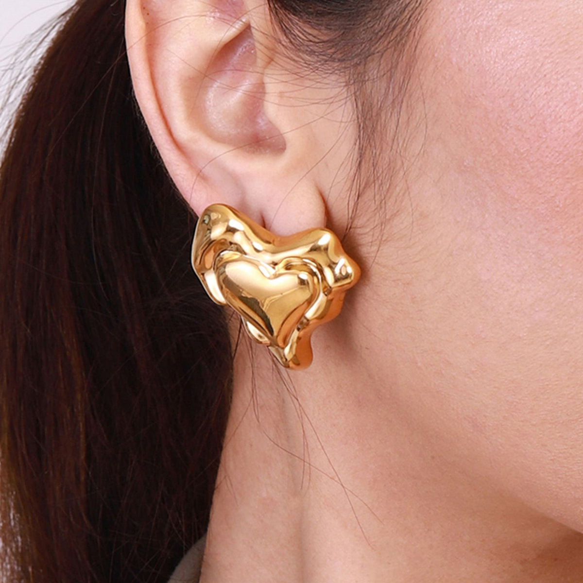Gold-Tone Sculptural Heart Stainless Steel Stud Earrings in Two Sizes – styled view
