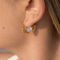 gold plated half-moon clear-stone hoop earring worn on ear