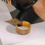 Open ring with gold and silver-colored tassel strands