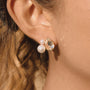 gold plated pear-cut and pearlized cluster stud earring worn on ear