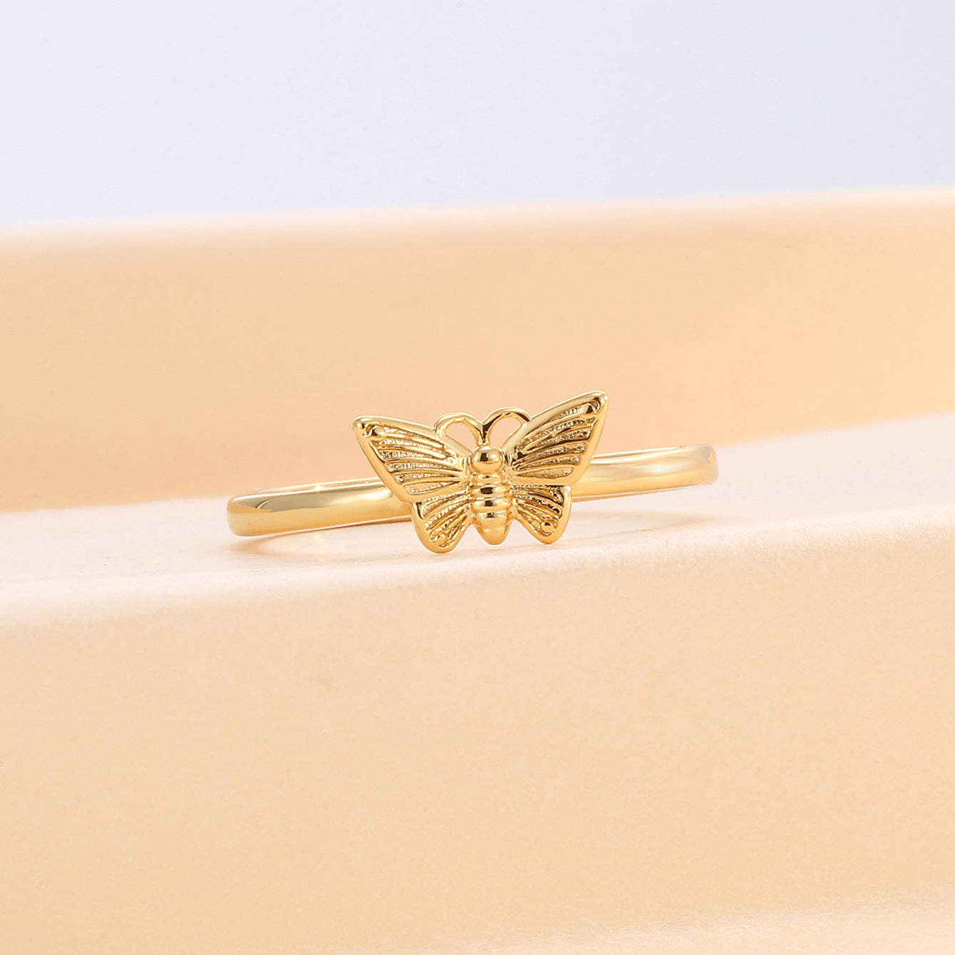 front view of open butterfly wings and slim polished band