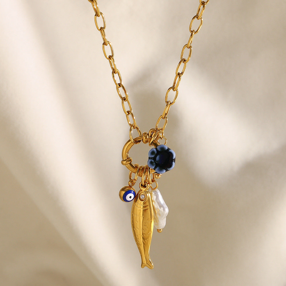 Gold plated fish charm necklace styled close-up