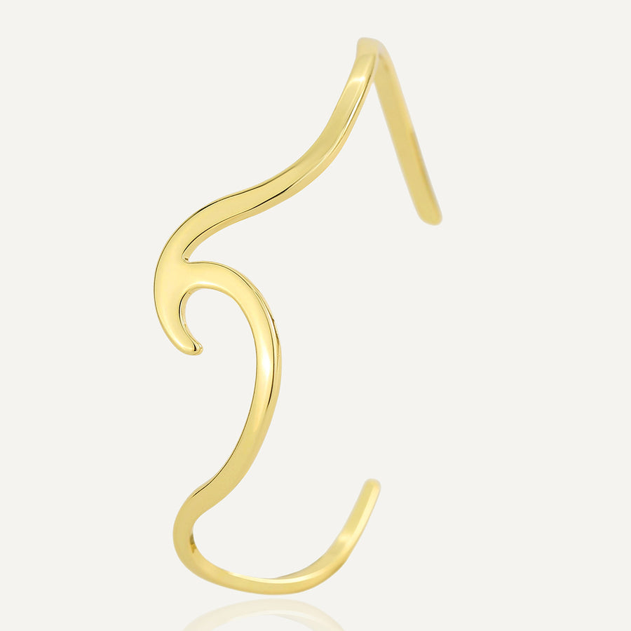 isolated gold plated brass open cuff shaped like a curling wave