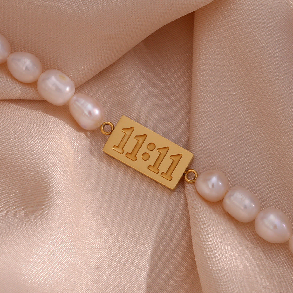 Close-up of the 11:11 plaque between oval freshwater pearls
