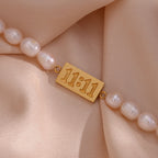 Close-up of the 11:11 plaque between oval freshwater pearls