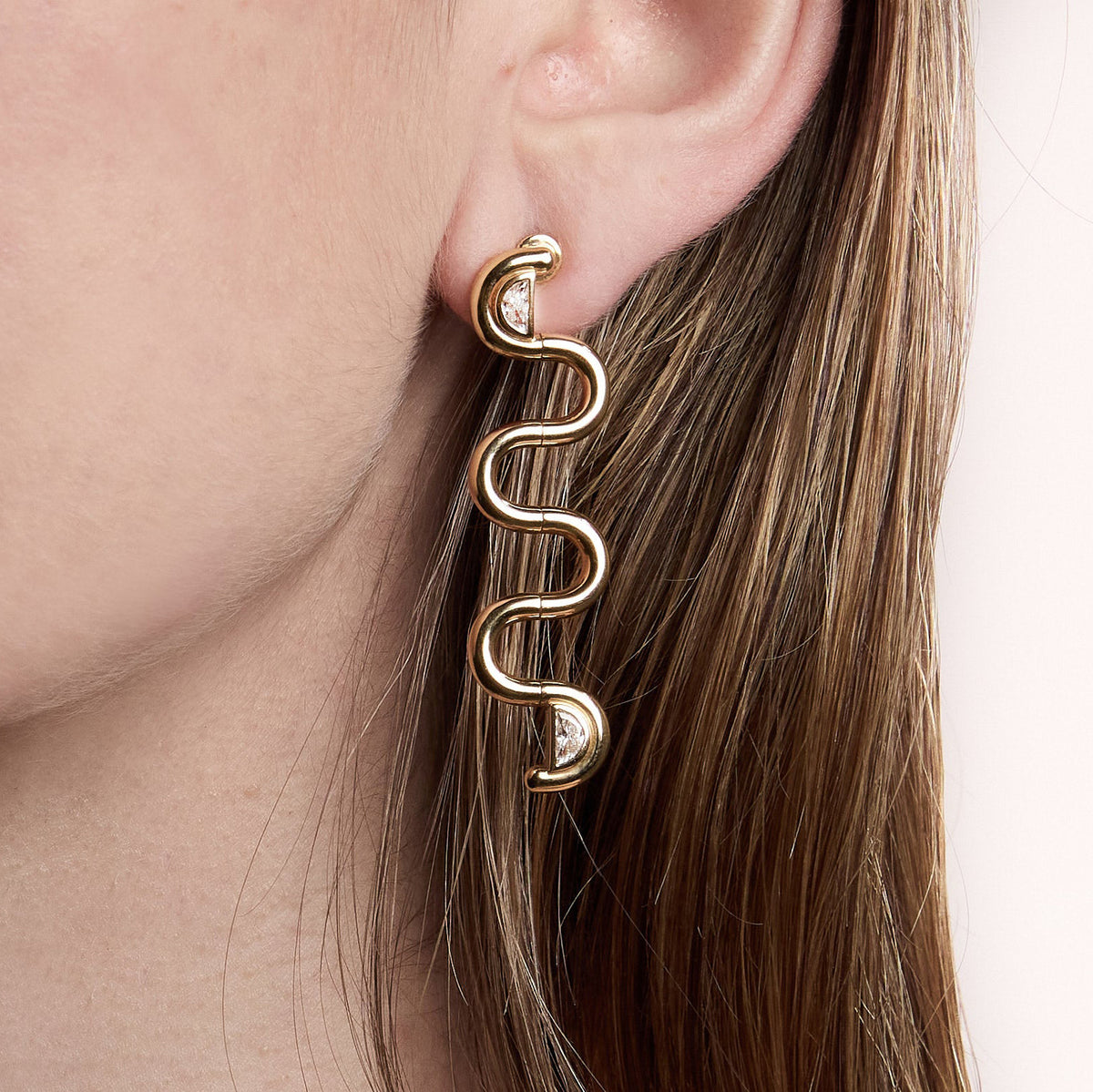 Long wave earring shown close-up on an ear