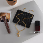 gold plated cross charm necklace styled beside accessories