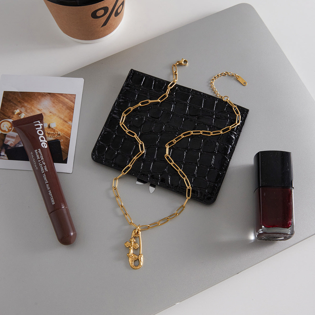 gold plated cross charm necklace styled beside accessories