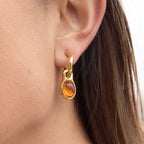 side view of amber-color resin cabochon hoop earring