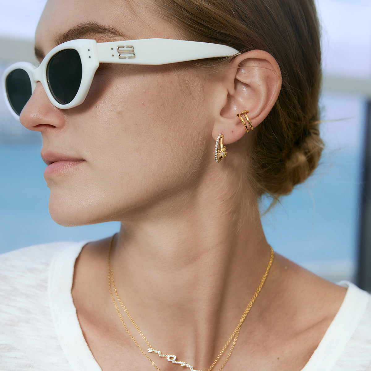 Gold tone starburst earring shown in model profile