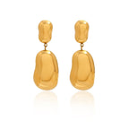 isolated pair of gold plated sculptural pebble drop earrings