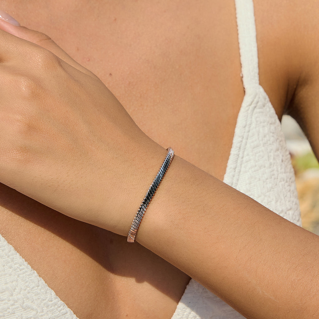 Plain silver tone snake chain bracelet worn on wrist