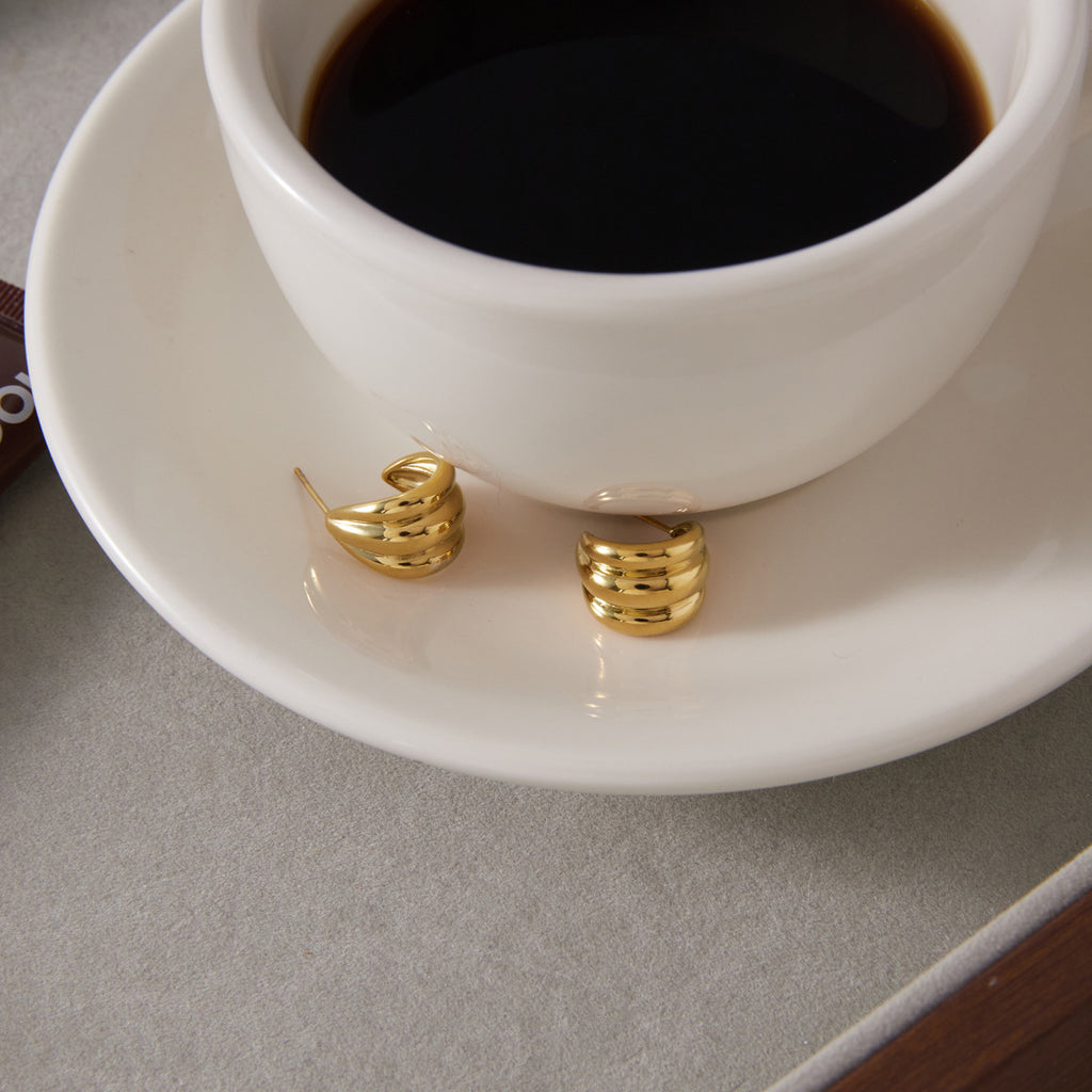 Small ridged hoops beside a coffee cup