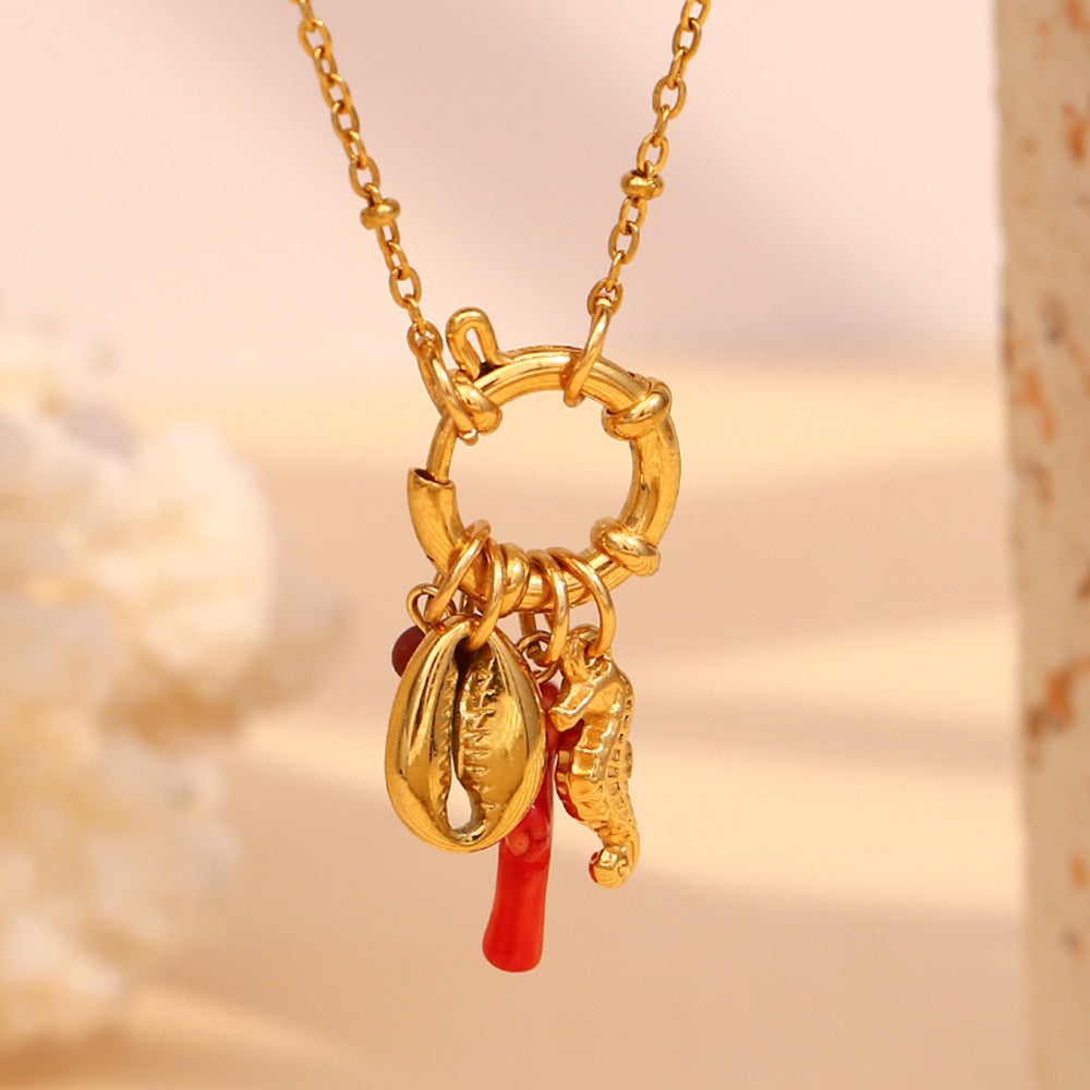 Gold plated stainless steel necklace with seahorse, cowrie shell and red charms