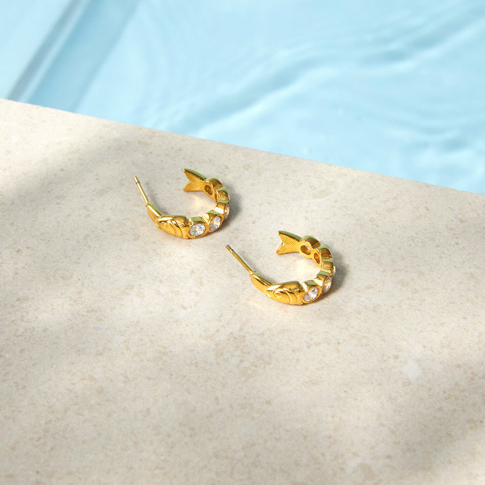 Clear stone fish hoops arranged on a pale stone surface