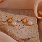 Gold plated green stone and freshwater pearl drop earrings styled on stone
