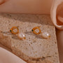 Gold plated green stone and freshwater pearl drop earrings styled on stone
