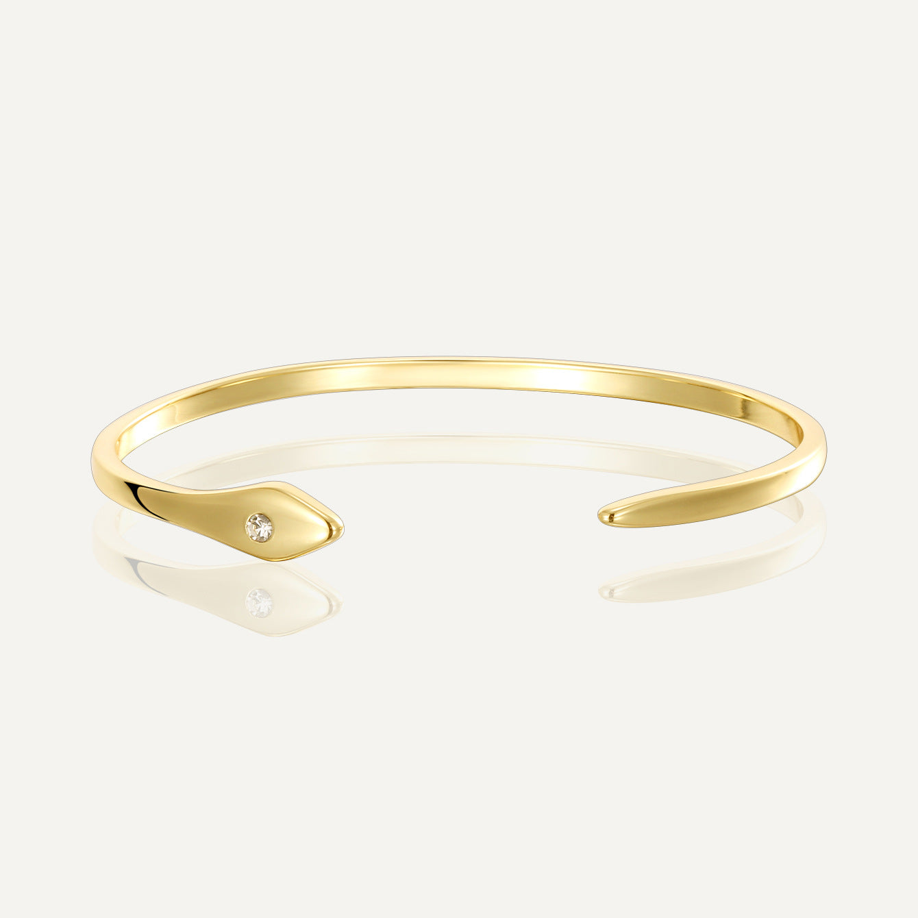 gold plated tapered open cuff with a single clear zirconia terminal