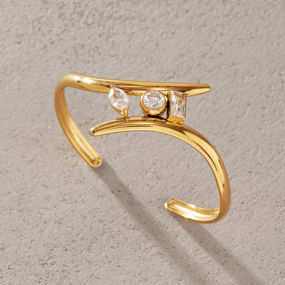 Gold-tone open cuff with three differently shaped clear stones