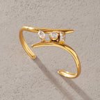 Gold-tone open cuff with three differently shaped clear stones