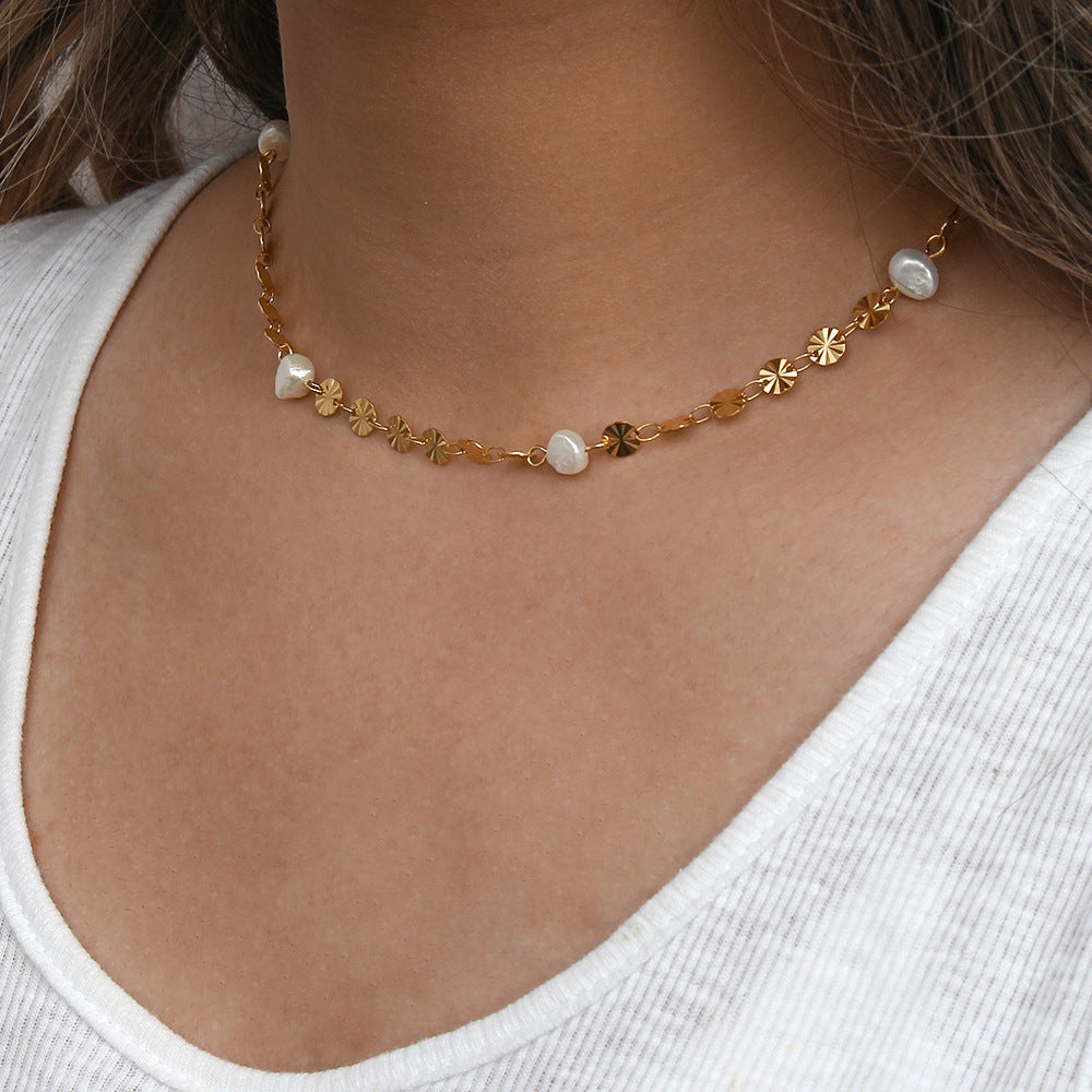 Close wearing view of the sunburst disc and pearl necklace