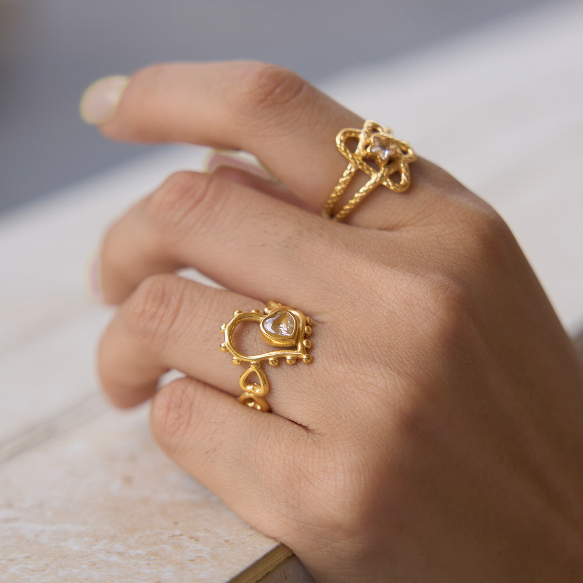 Close-up of looped star and open heart ring designs