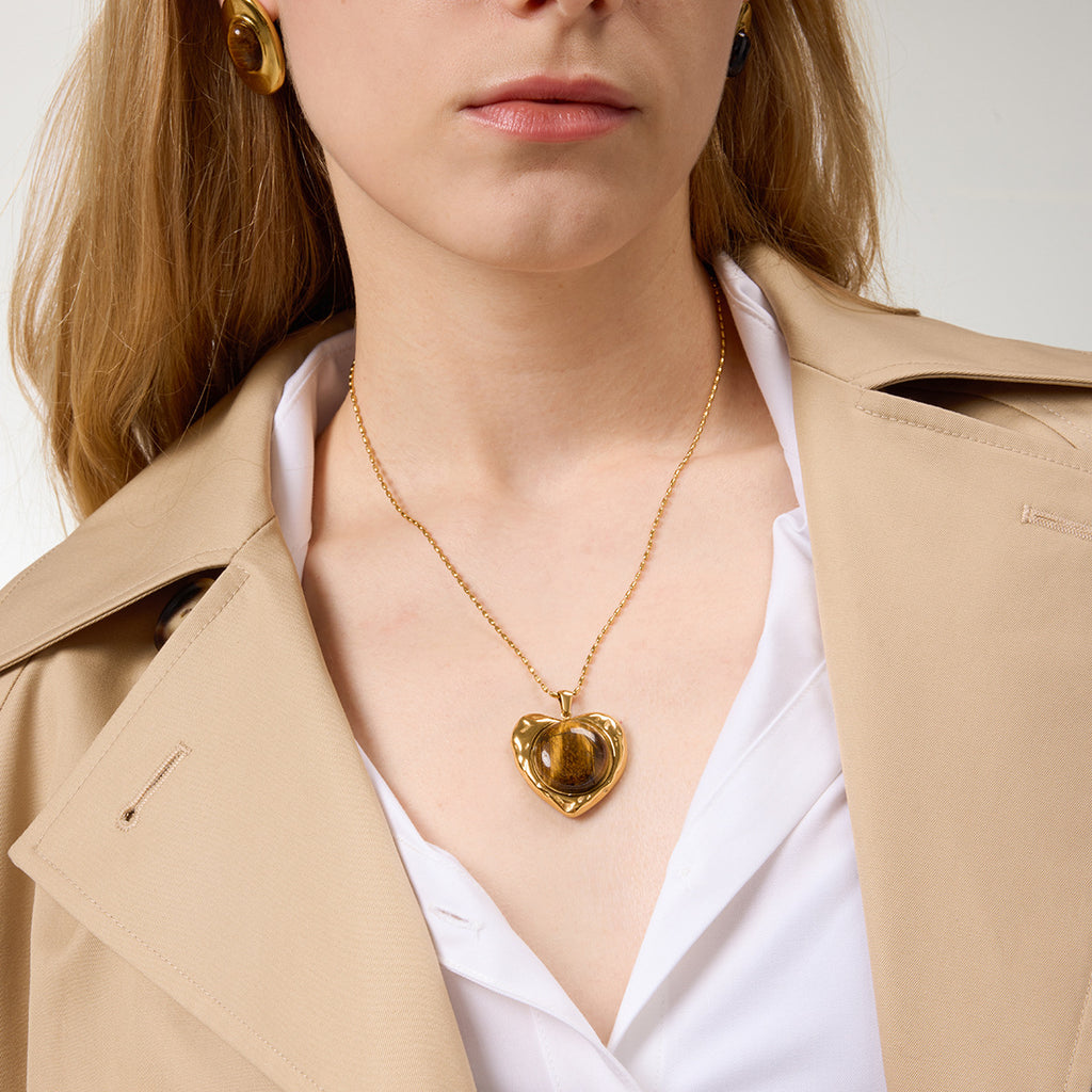 Model wearing gold-tone stainless steel heart pendant necklace