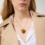 Model wearing gold-tone stainless steel heart pendant necklace