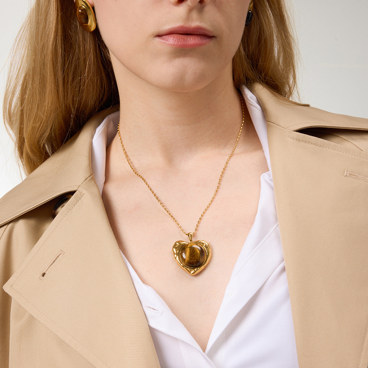 Model wearing gold-tone stainless steel heart pendant necklace