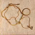 Layered imitation pearl initial necklace arranged on a stone surface