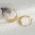 gold plated leaf branch clear stone hoop earrings on pale stone