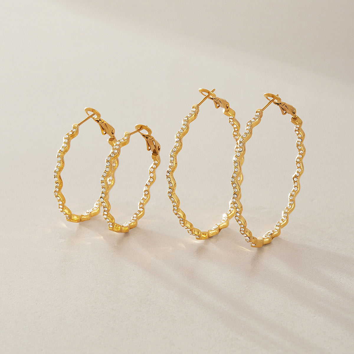 Two sizes of gold tone wavy hoops