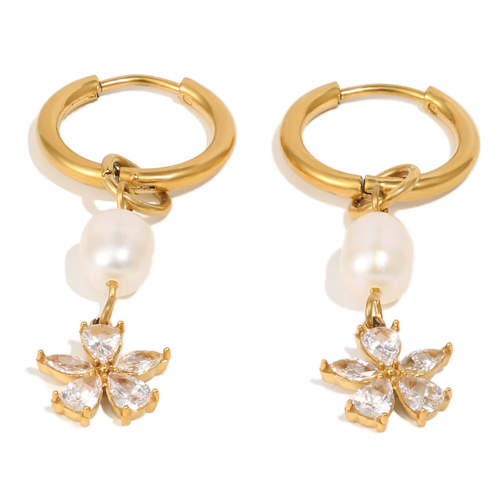 gold plated huggie earrings with pearl and floral charms on white