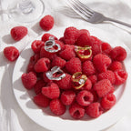 Clear stone cuffs in two finishes beside raspberries
