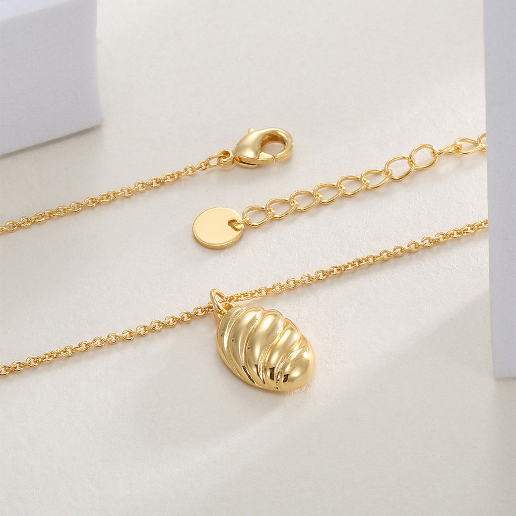 ribbed oval pendant necklace laid beside its lobster clasp and extender